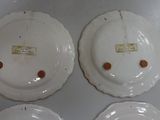 three white plates with brown spots on them sitting on top of a table