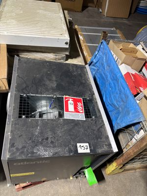une boîte métallique sur laquelle est apposée une étiquette, posée au milieu d'une pile de boîtes