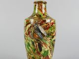 a vase with a bird on it sitting on a table