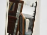a mirror on the wall reflecting a dining room table