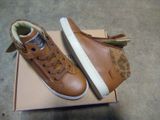 une boîte sur laquelle est posée une paire de chaussures marron