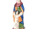 figurine d'une femme tenant un enfant dans ses bras