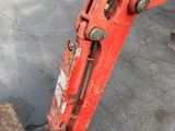 a red excavator that is sitting on the ground