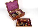 une petite boîte en bois contenant des dés et des cartes