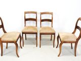four wooden chairs with cane back and cane seat cushions