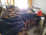 a pile of wood in a room with a lot of bags on the floor
