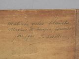 an old book with writing on it sitting on top of a table