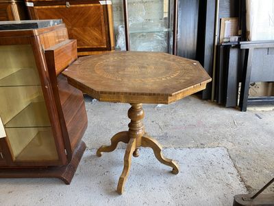 une petite table avec un plateau en bois sur un sol en ciment