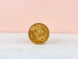 a gold coin sitting on top of a white surface