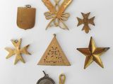 several different types of brass ornaments are displayed on a white surface