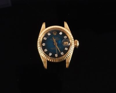 a close up of a gold watch with a blue dial and diamonds