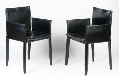 pair of black leather dining chairs with armrests against a white background