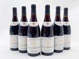 six bouteilles de vin sont alignées sur une surface blanche
