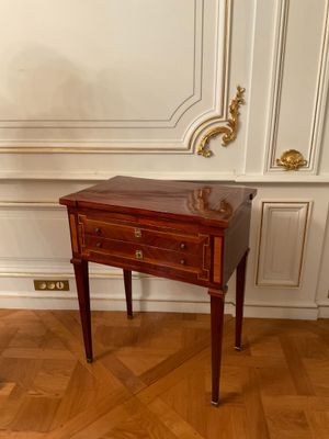 a small table with two drawers on it in a room