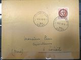 une vieille enveloppe sur laquelle sont collés deux timbres, posée sur une table