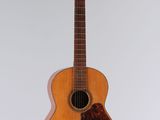 an acoustic guitar hanging from a string on a white wall