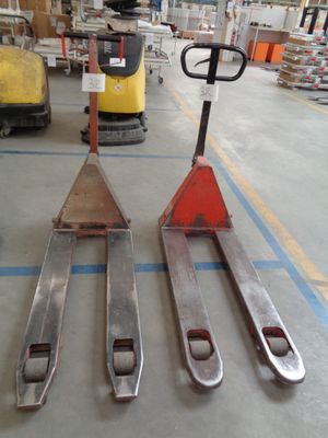 three forklifts sitting on the floor in a warehouse