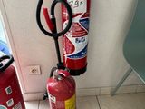 two fire extinguisors sitting next to each other on the floor