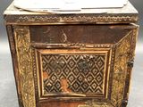 an old wooden box sitting on top of a table covered in paper
