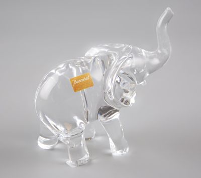 figurine d'éléphant en verre transparent, avec une étiquette jaune accrochée à sa trompe