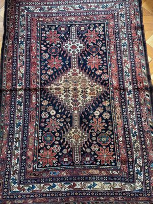 un tapis persan antique sur un plancher en bois