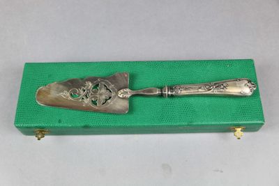 une vieille cuillère en argent posée sur une boîte verte