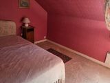 a bedroom with a pink wall and a white bed in it