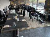 tables and chairs set up in a restaurant with a view of the outside