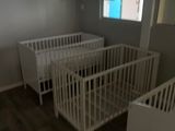 deux lits bébé dans une petite pièce dotée d'une fenêtre