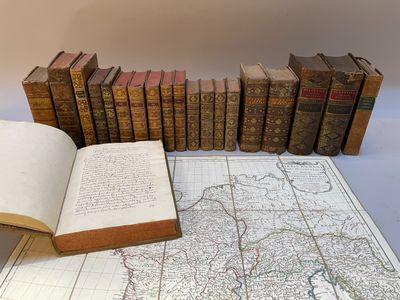 plusieurs vieux livres sur une table à côté d'une carte et d'un livre