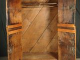 a wooden cabinet with a door open on a black background