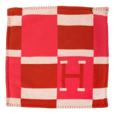 une couverture à carreaux rouges et blancs sur laquelle figure la lettre h