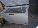 a white chest freezer sitting on the ground