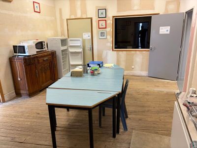 une table et des chaises dans une pièce équipée d'un réfrigérateur
