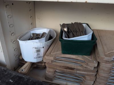a stack of wood chips and a bucket of spoons on a shelf