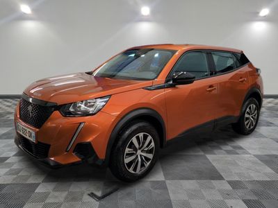 un SUV orange garé sur un sol à damier dans un garage
