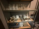 a shelf full of dishes and glasses in a kitchen