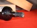 a bottle of wine sitting on a table next to a wooden box