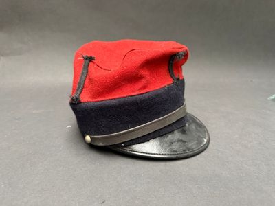 un chapeau rouge et noir posé sur une table