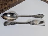 two spoons and a fork sitting on a table