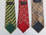 three ties with different designs on them on a white surface