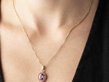 a close up of a woman wearing a black shirt and a gold necklace