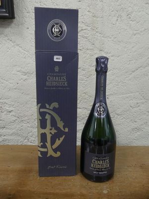 une bouteille de champagne posée sur une table à côté d'une boîte