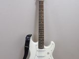 une guitare électrique blanche avec une sangle noire