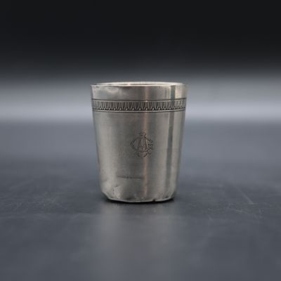 a close up of a silver shot glass on a table