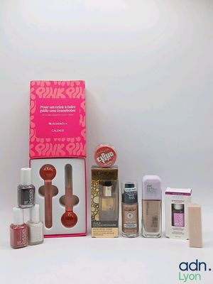 the contents of a pink box of makeup are displayed on a white surface
