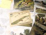 une table sur laquelle sont posées de nombreuses cartes postales et photos