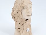 a clay sculpture of a woman ' s head wearing a hat