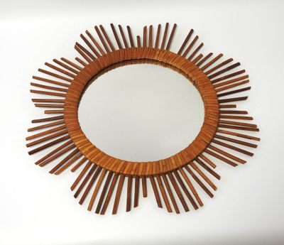 a close up of a wooden mirror on a white wall