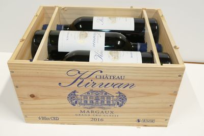 des bouteilles de vin se trouvent dans un coffret en bois sur une table
